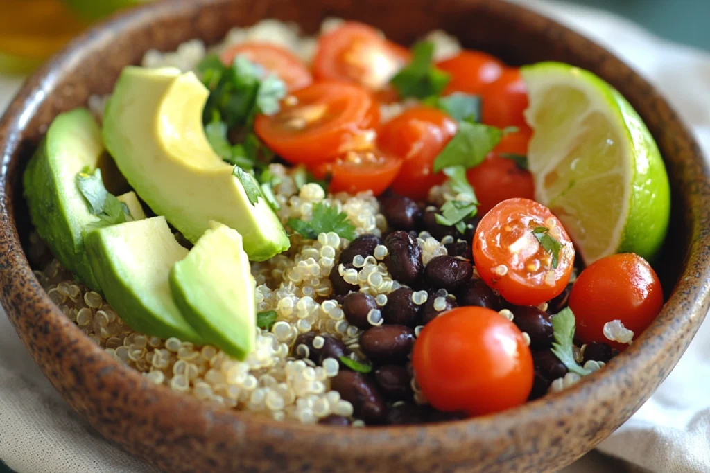 High Protein Lunch Ideas for Muscle Gain 3 Quinoa and black bean bowl with avocado, cherry tomatoes, and lime served in a rustic bowl.